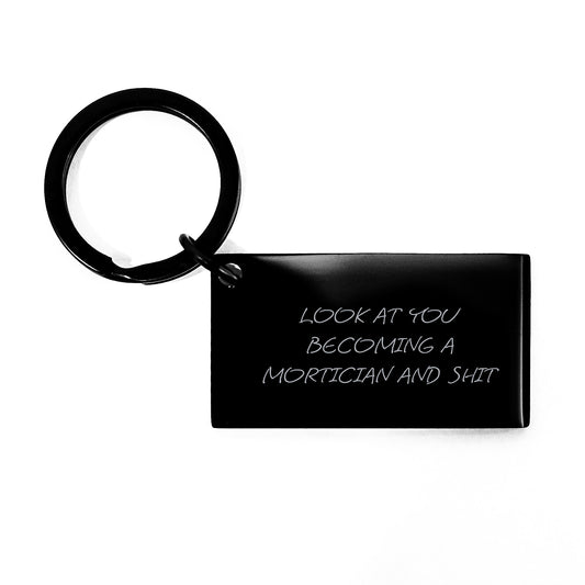 Mortician Keychain, Funny Graduation Gift from Family to Mortician, 'Look At You Becoming A Mortician And Shit' Quote, Black Stainless Steel Keychain, 1.57 x 0.87 inches - Image 1